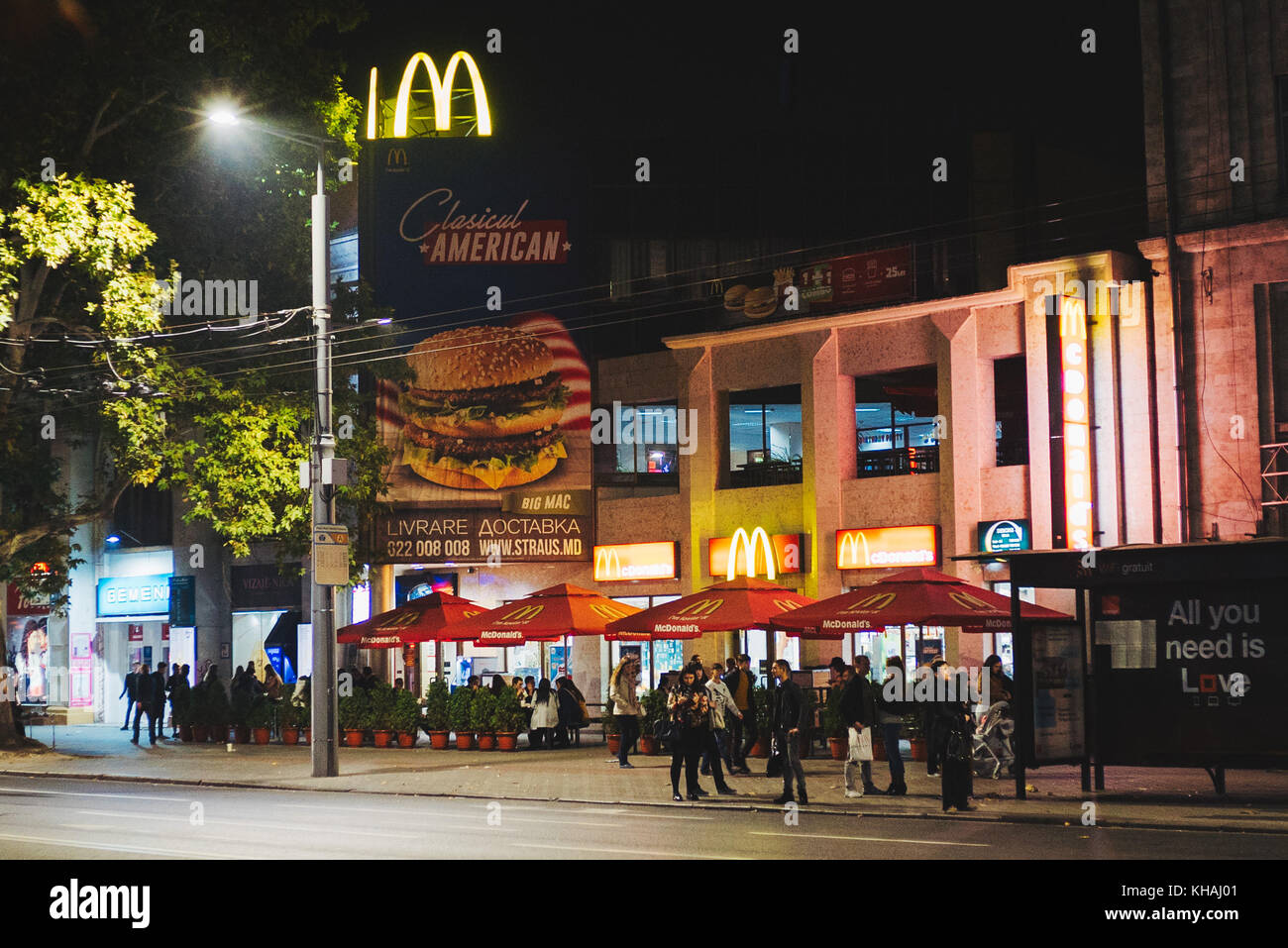 Uno dei pochi ristoranti mcdonald's a Chisinau, in Moldavia, annuncia un 'classico americano' big mac mentre patroni sedersi davanti a mangiare fast food Foto Stock