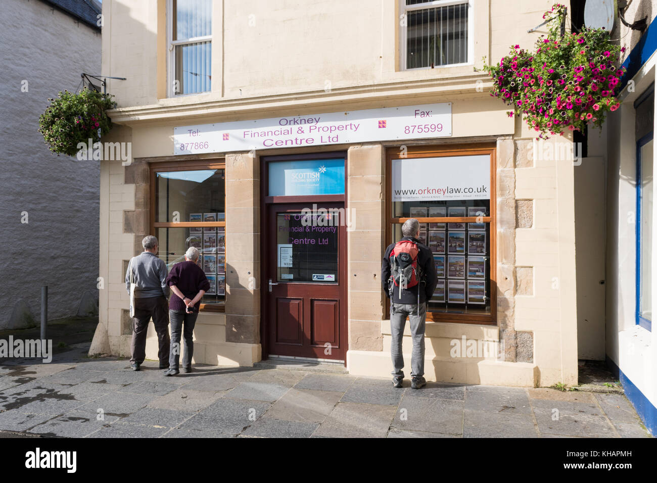 Persone che cercano nelle finestre di Orkney Financial e Property Center agenzia immobiliare, Kirkwall, Orkney, Scozia, Regno Unito Foto Stock