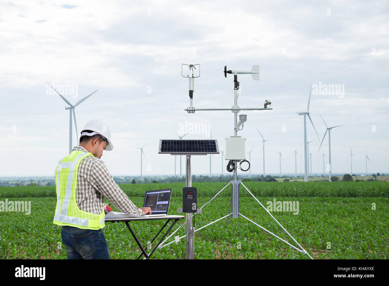 Ingegnere utilizzando computer tablet di raccogliere dati con strumenti meteorologici per misurare la velocità del vento, temperatura e umidità e di cella solare o di sistema Foto Stock