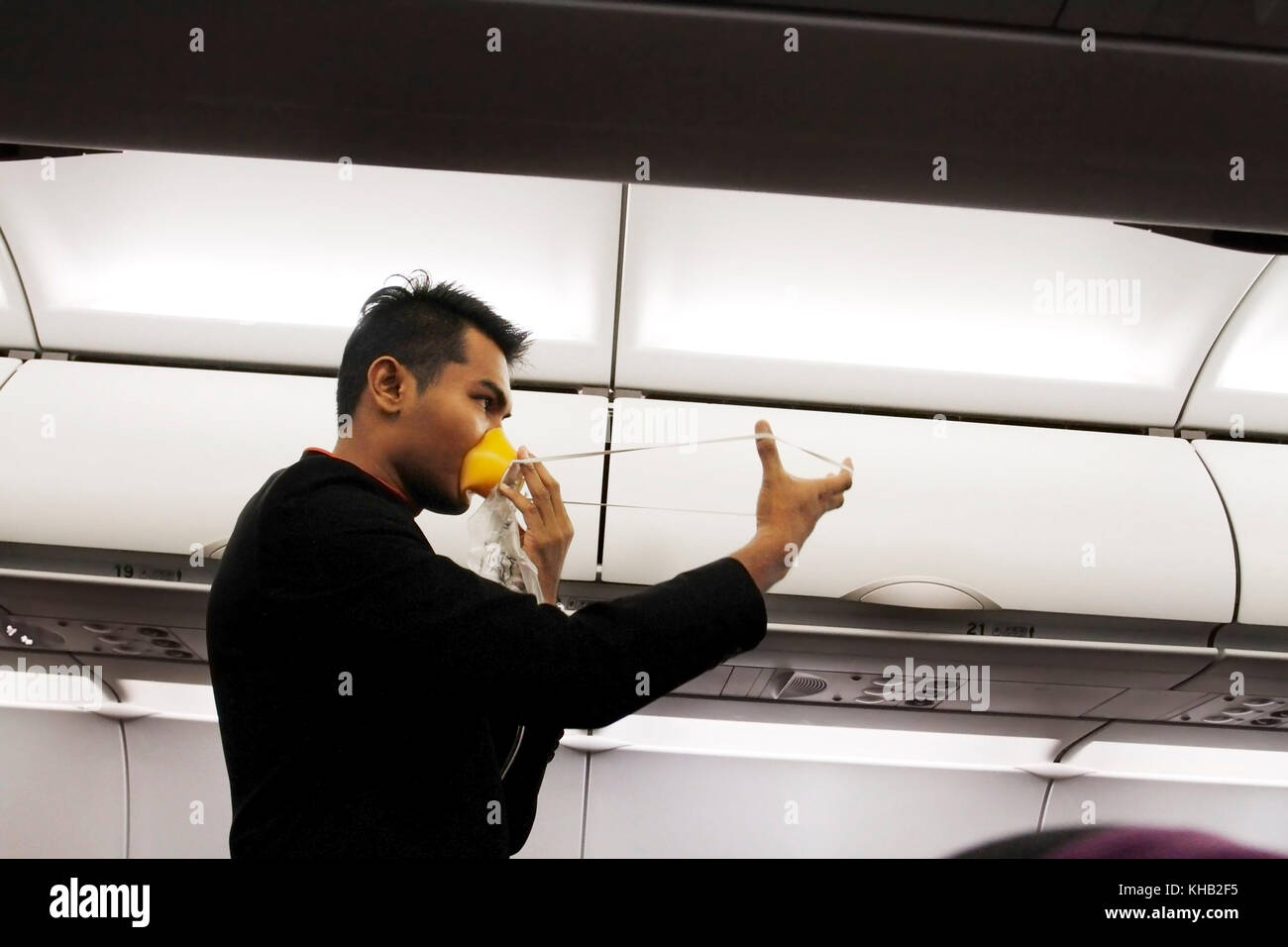 Uno steward demonstratiing procedura di sicurezza prima del decollo..L'uomo Foto Stock