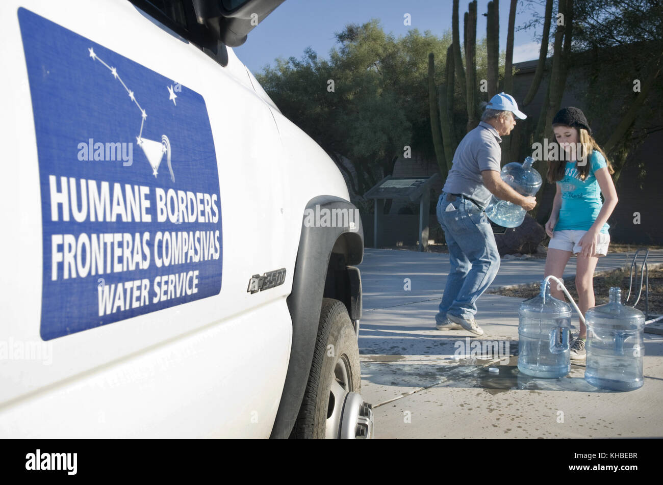 Ajo, Arizona, Stati Uniti. 16 Ott 2010. Volontari di confine umano Lawn Griffiths, Caetlin Asher, 12, (figlia del volontario John Asher) riempiono cinque galloni di bottiglie d'acqua utilizzate per rifornire le stazioni d'acqua in e intorno al monumento nazionale di Organ Pipe nel deserto di sonora a sud di Ajo Arizona. Humane Borders mantiene più di 100 stazioni di acqua lungo il confine tra Stati Uniti e Messico nel tentativo di arginare il numero di morti dei migranti che entrano negli Stati Uniti, utilizzando le rotte più pericolose e inospitali attraverso il deserto. Anche se il numero di persone di attraversamento illegale negli Stati Uniti attraverso l'Arizona è basso, il dea Foto Stock