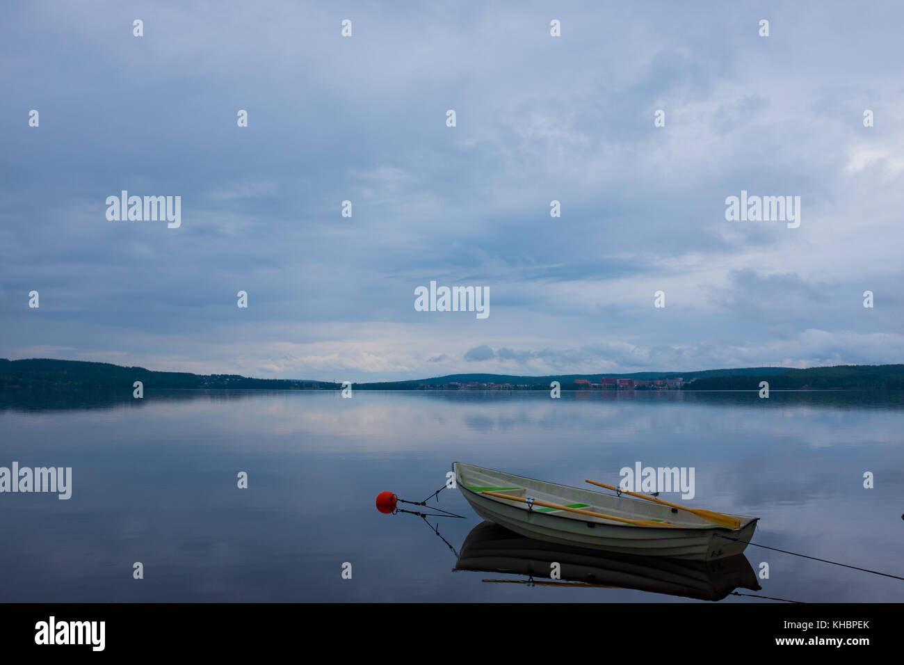 Un ormeggiati canotto da un tranquillo lago nel nord della Svezia Foto Stock