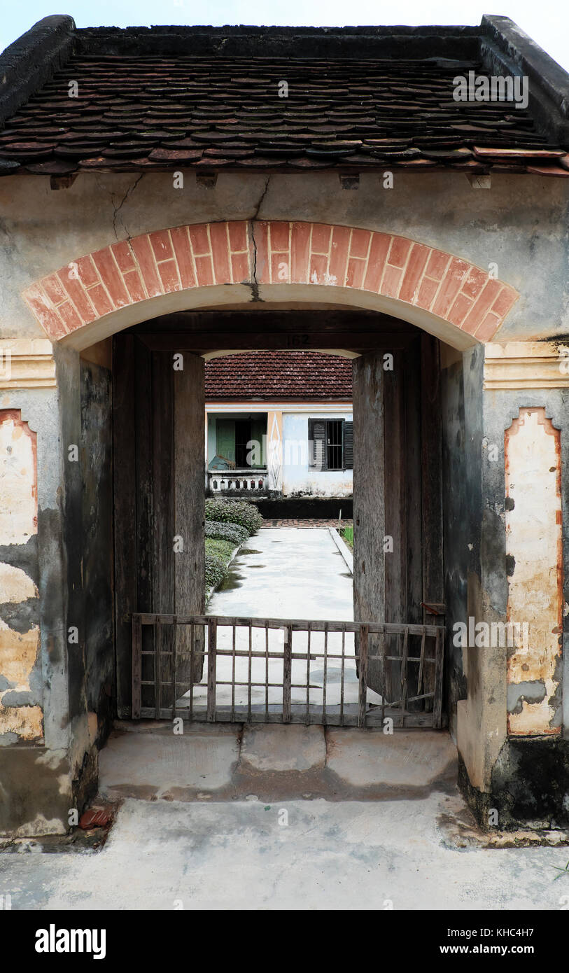 Il vietnamita antica casa di legno con porta finestra in legno e sorprendente grande cancello di calcestruzzo, la vecchia casa con architettura tradizionale del giorno, Vietnam Foto Stock