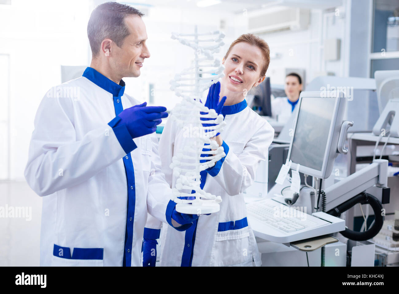 In erba scienziati meditativo team usando il modello di DNA Foto Stock