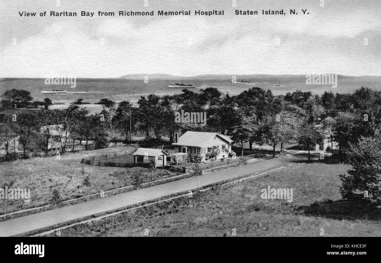 Cartolina che mostra una vista aerea degli edifici in un campo, con una baia sullo sfondo, intitolato 'Vista della Baia di Raritan dal Richmond Memorial Hospital, Staten Island, New York', Staten Island, New York, 1900. Dalla Biblioteca pubblica di New York. Foto Stock