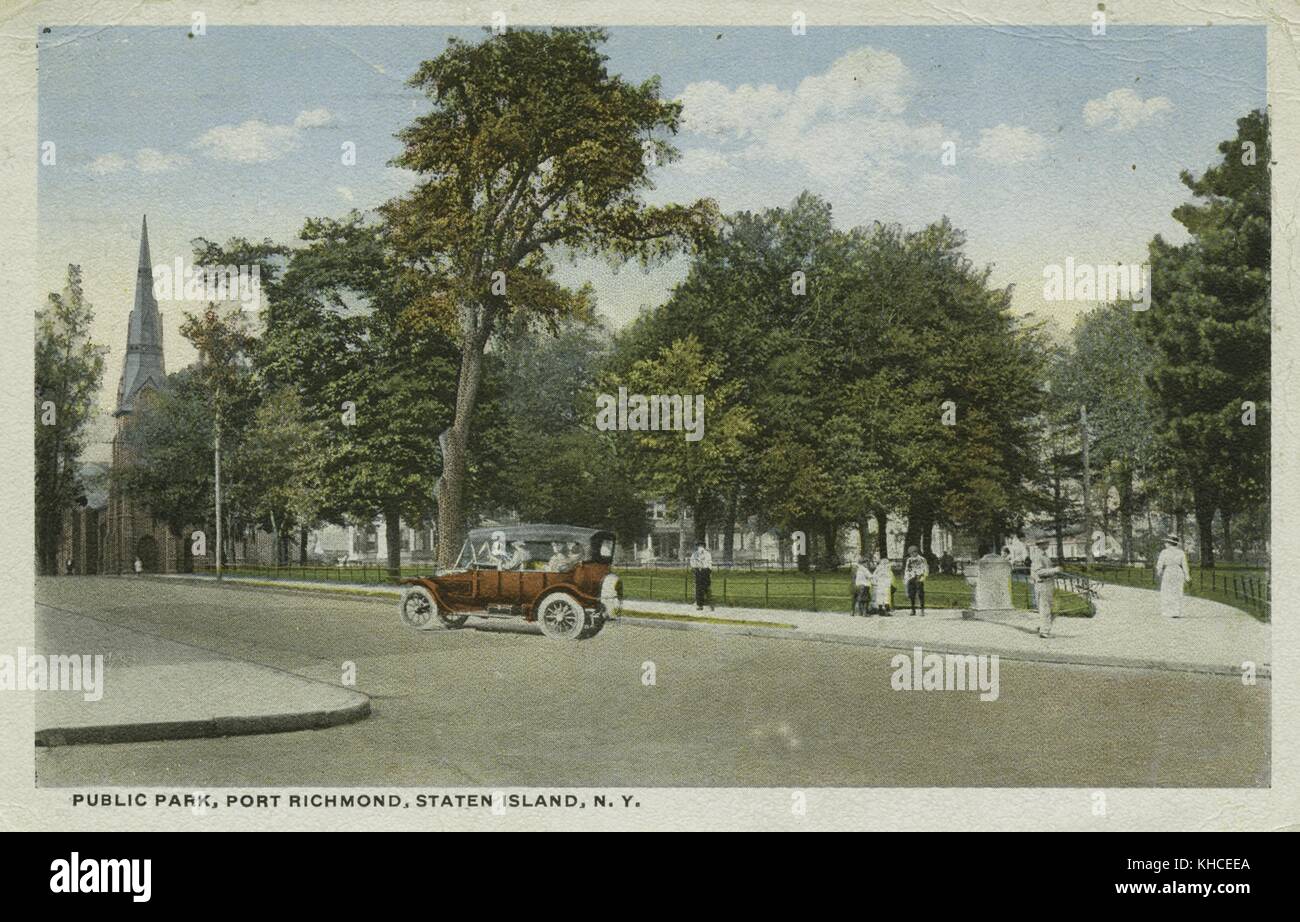 Una cartolina da un'immagine di un parco pubblico, si può vedere la gente intorno alla periferia del parco mentre un'automobile è mostrata guidando sulla strada, i passaggi pedonali del parco sono separati dall'erba e gli alberi da recinzioni di metallo basse, una chiesa e la sua guglia sono visti sullo sfondo, 1900. Dalla Biblioteca pubblica di New York. Foto Stock