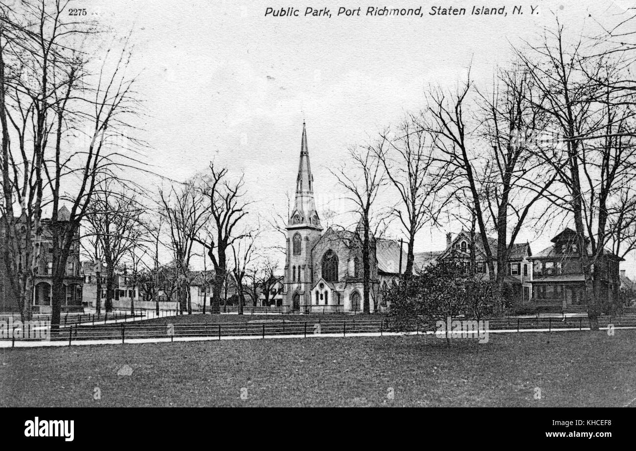 Una cartolina da una fotografia di un parco pubblico, il parco coperto di erba contiene passerelle con recinzioni che li fiancheggiano, alberi sono anche visto crescere all'interno del parco, una chiesa e residenze si possono vedere intorno al parco, Port Richmond, Staten Island, New York, 1900. Dalla Biblioteca pubblica di New York. Foto Stock