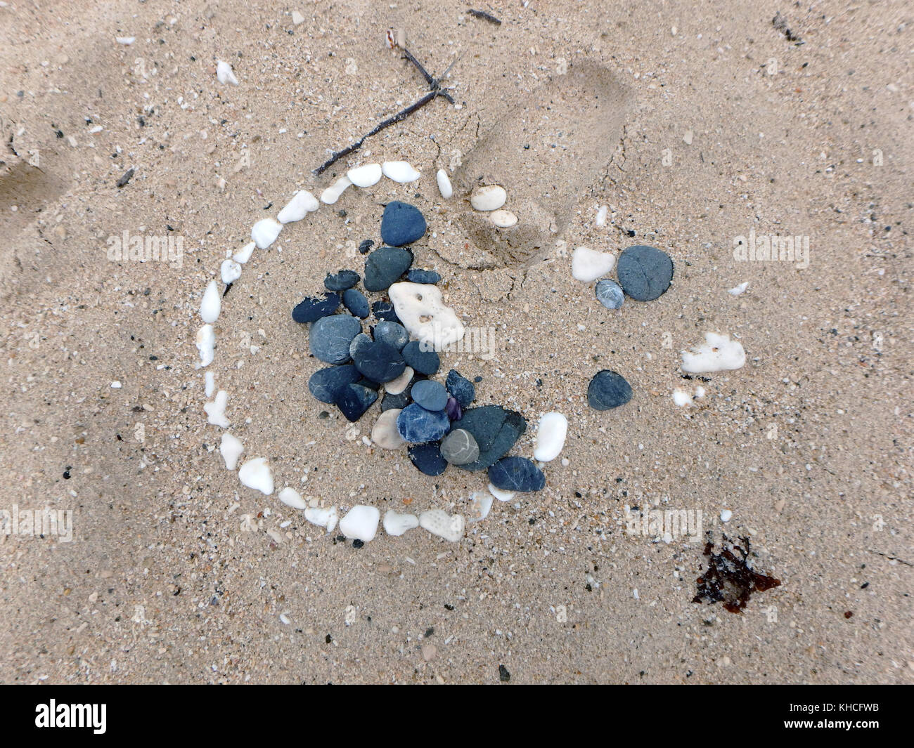 Disposizione di pietra sulla sabbia spazzato dalla marea Foto Stock