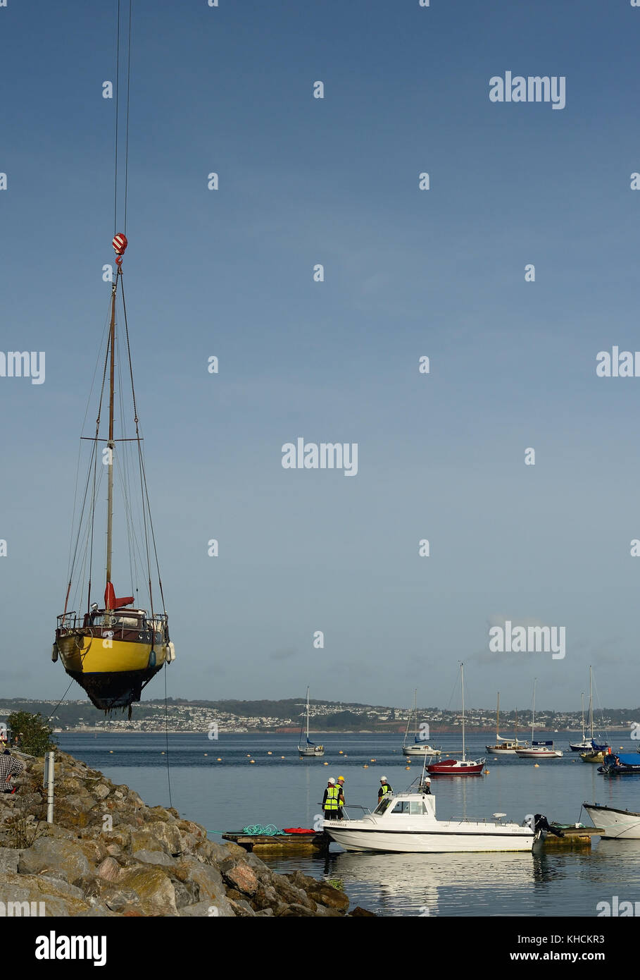 Barca che viene sollevato fuori dall'acqua a Brixham Harbour. Foto Stock