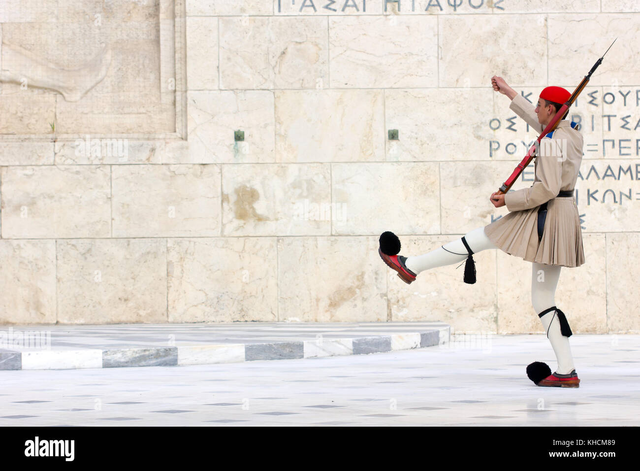 Il greco guardia presidenziale chiamato tsoliades vestito in uniforme tradizionale presso il monumento del milite ignoto di fronte al parlamento greco, Foto Stock