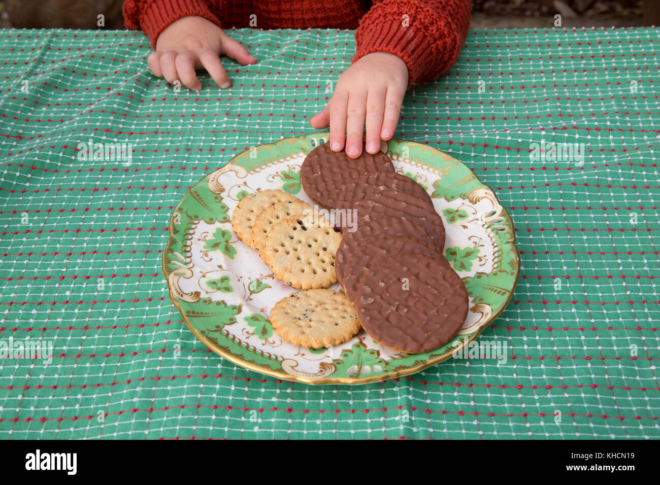 Ragazzo a tavola la scelta di biscotti al cioccolato dalla piastra, ritagliato dettaglio Foto Stock