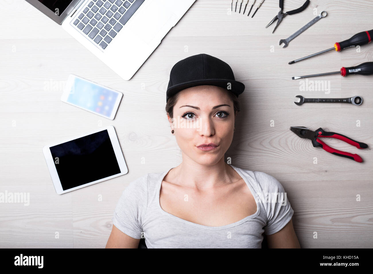 Donna risolvendo ogni hardware e software it problema con il suo cappello nero e atteggiamento positivo Foto Stock