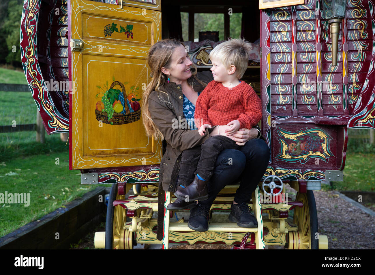 Donna e figlio seduti nella porta della tradizionale gypsy caravan Foto Stock