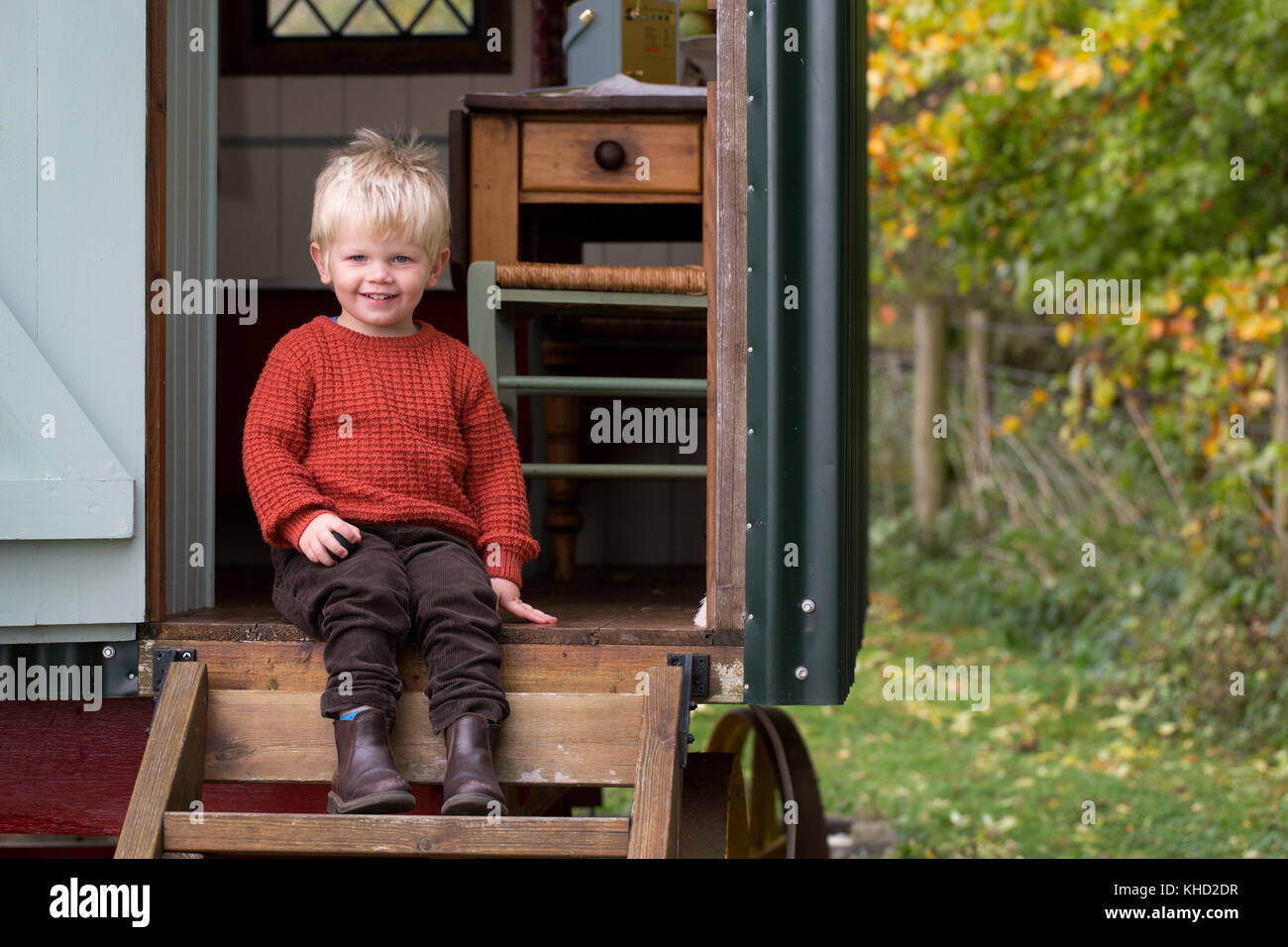 Ragazzo seduto nella porta della tradizionale gypsy caravan, ritratto Foto Stock
