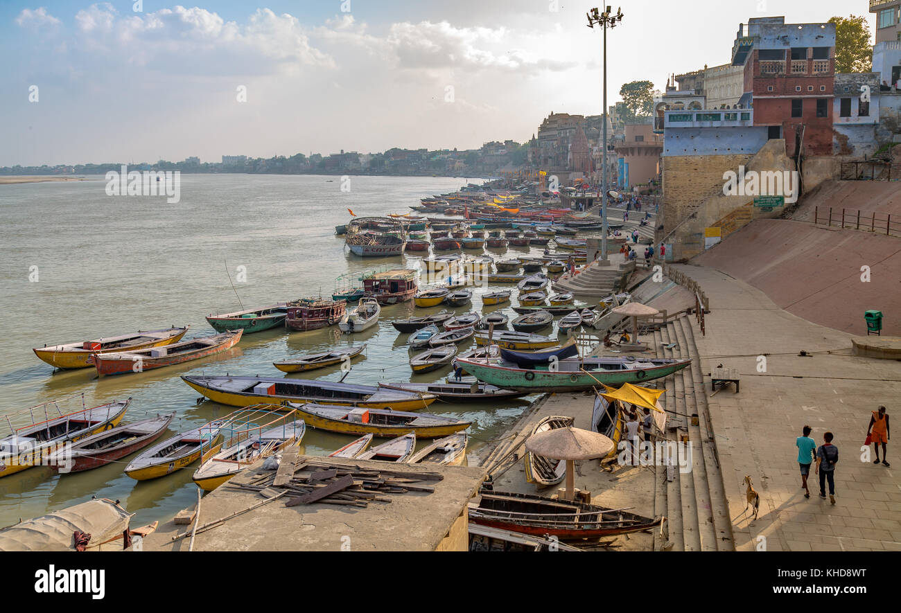 Vista aerea di varanasi gange fiume ghat con antiche strutture architettoniche templi e variopinte barche di legno. Foto Stock