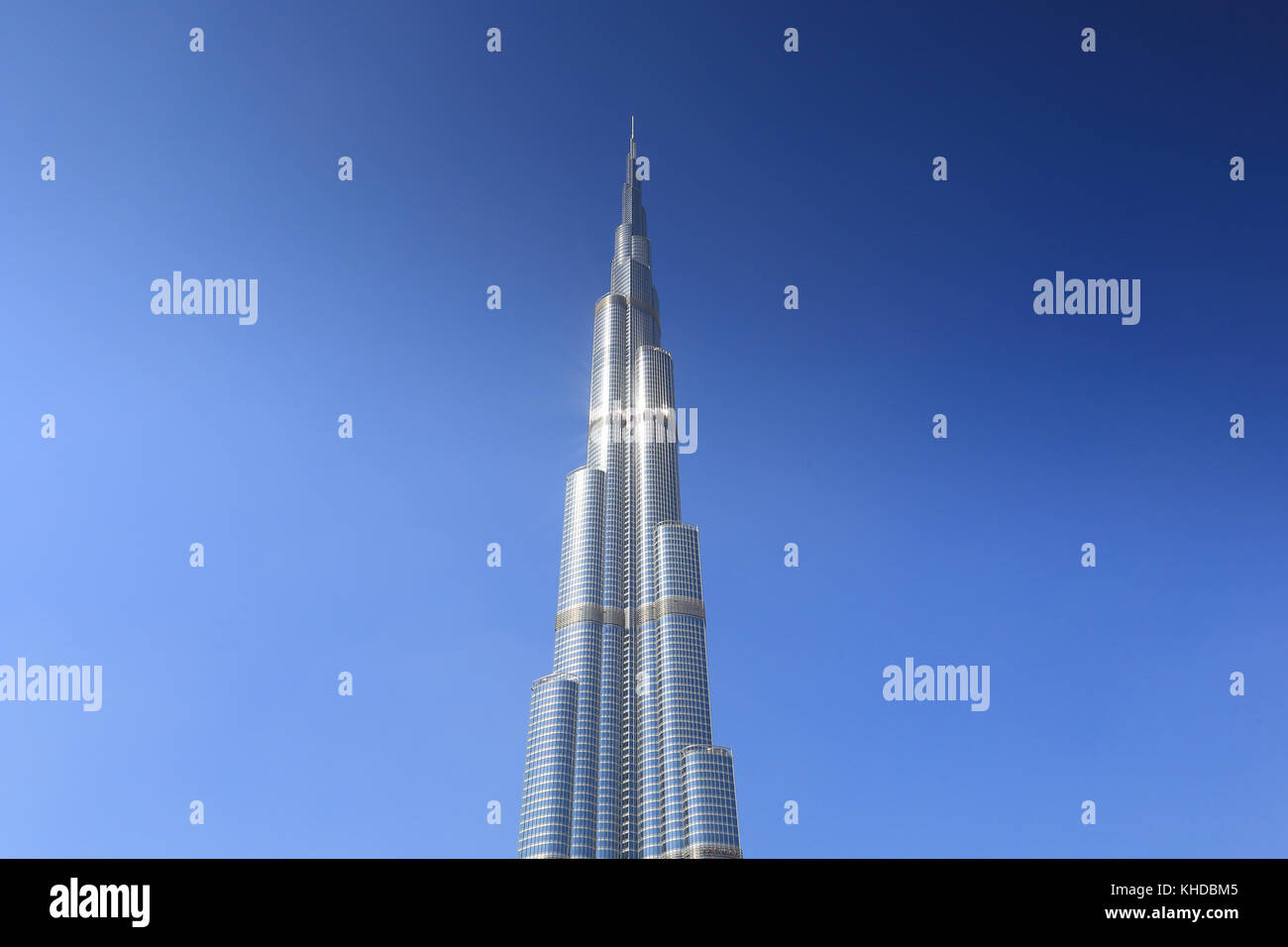 In alto di Burj Khalifa grattacielo sul cielo blu sullo sfondo Foto Stock