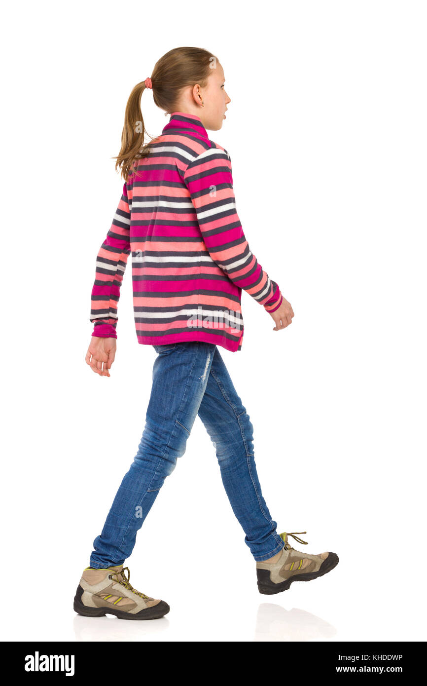 Teen girl in striped giacca di lana, jeans e scarpe da trekking a piedi e  guardando lontano. vista laterale. a piena lunghezza studio shot isolato su  bianco Foto stock - Alamy
