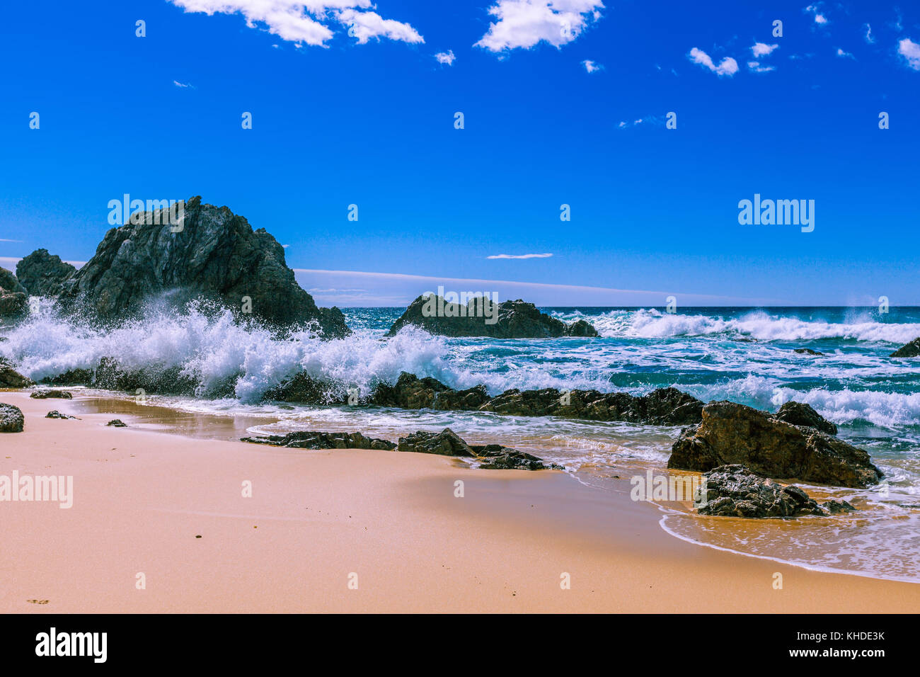 Oceano onde che si infrangono sulla bella aspre rocce sulla spiaggia sulla luminosa giornata di sole Foto Stock