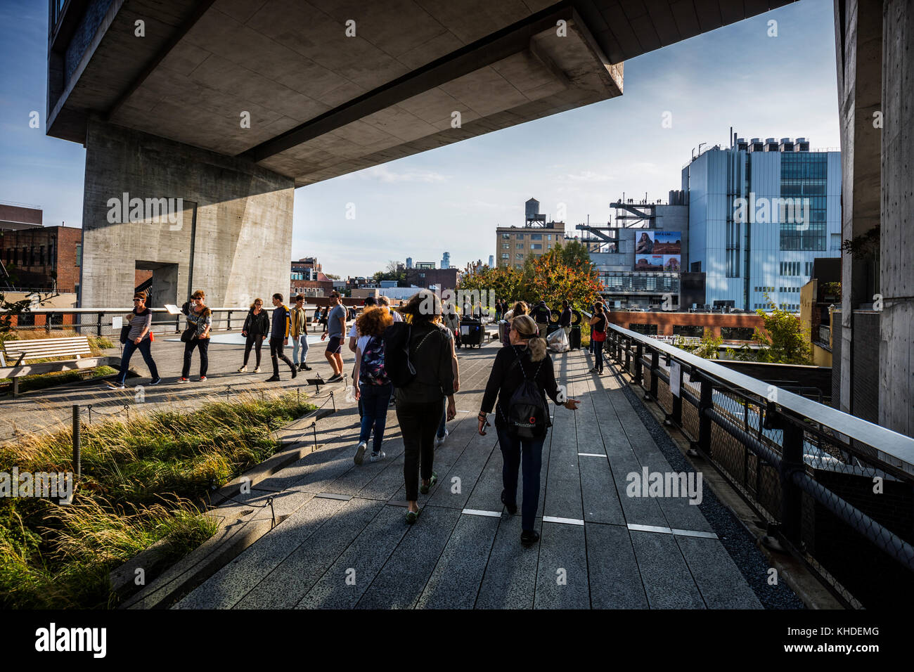 La gente che camminava sulla linea alta Park marciapiede, Whitney museum sul retro, New York City Foto Stock