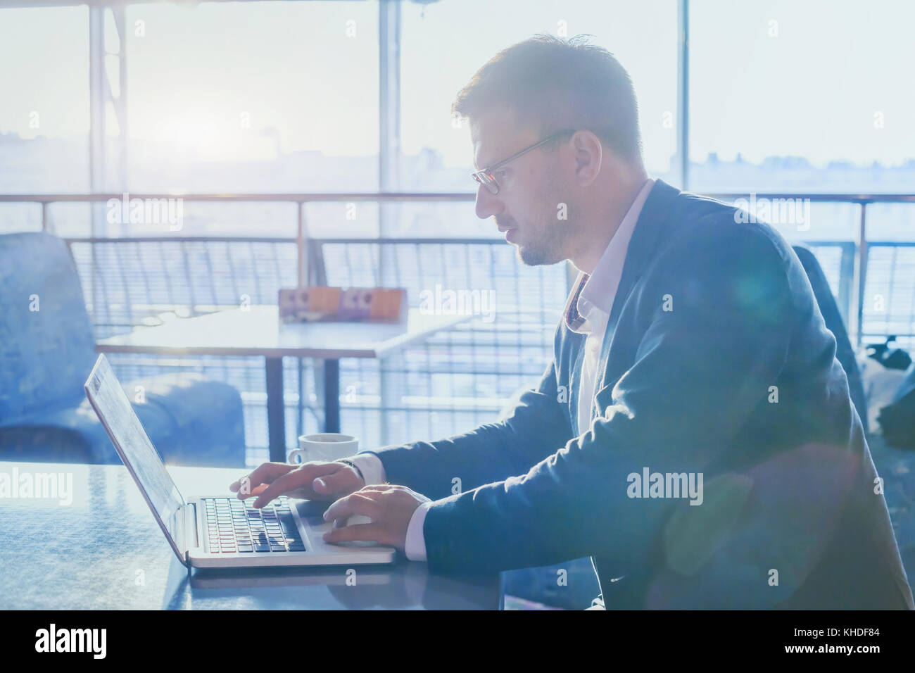 Imprenditore lavora su computer in ambienti moderni di aeroporto cafe, uomo utilizzando internet sul computer portatile, scrivere un'e-mail, online banking concept Foto Stock