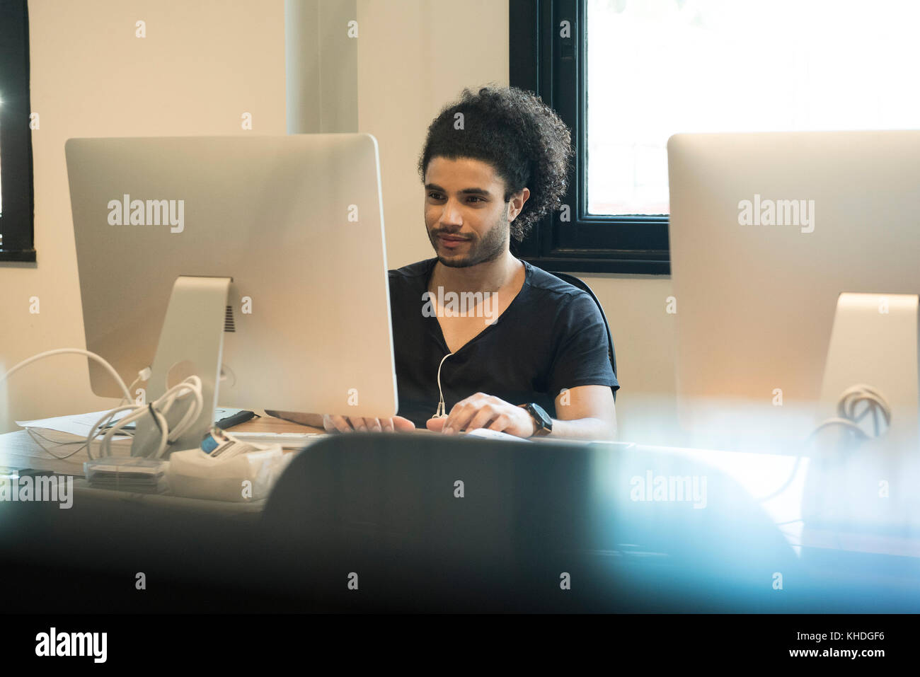 Giovane uomo tramite il computer desktop Foto Stock
