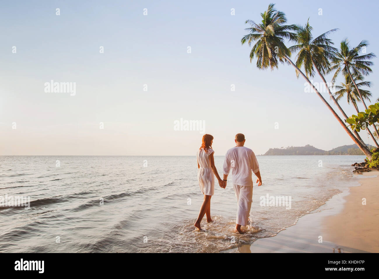 Romantico coppia giovane camminare insieme sulla bellissima esotica spiaggia tropicale al tramonto Foto Stock