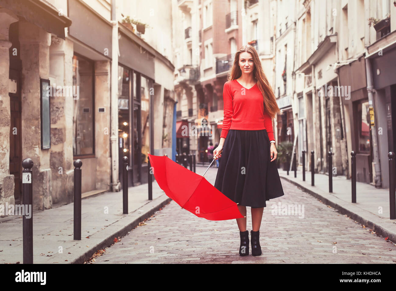 Ritratto di donna bella in rosso, attraente giovane ragazza caucasica corpo pieno con ombrellone, vintage filtro retrò Foto Stock