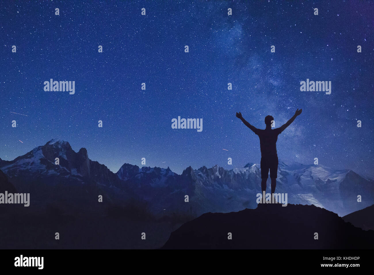 Persona in cerca di notte il cielo stellato , silhouette di un uomo in piedi con le mani alzate a sognare stelle Foto Stock
