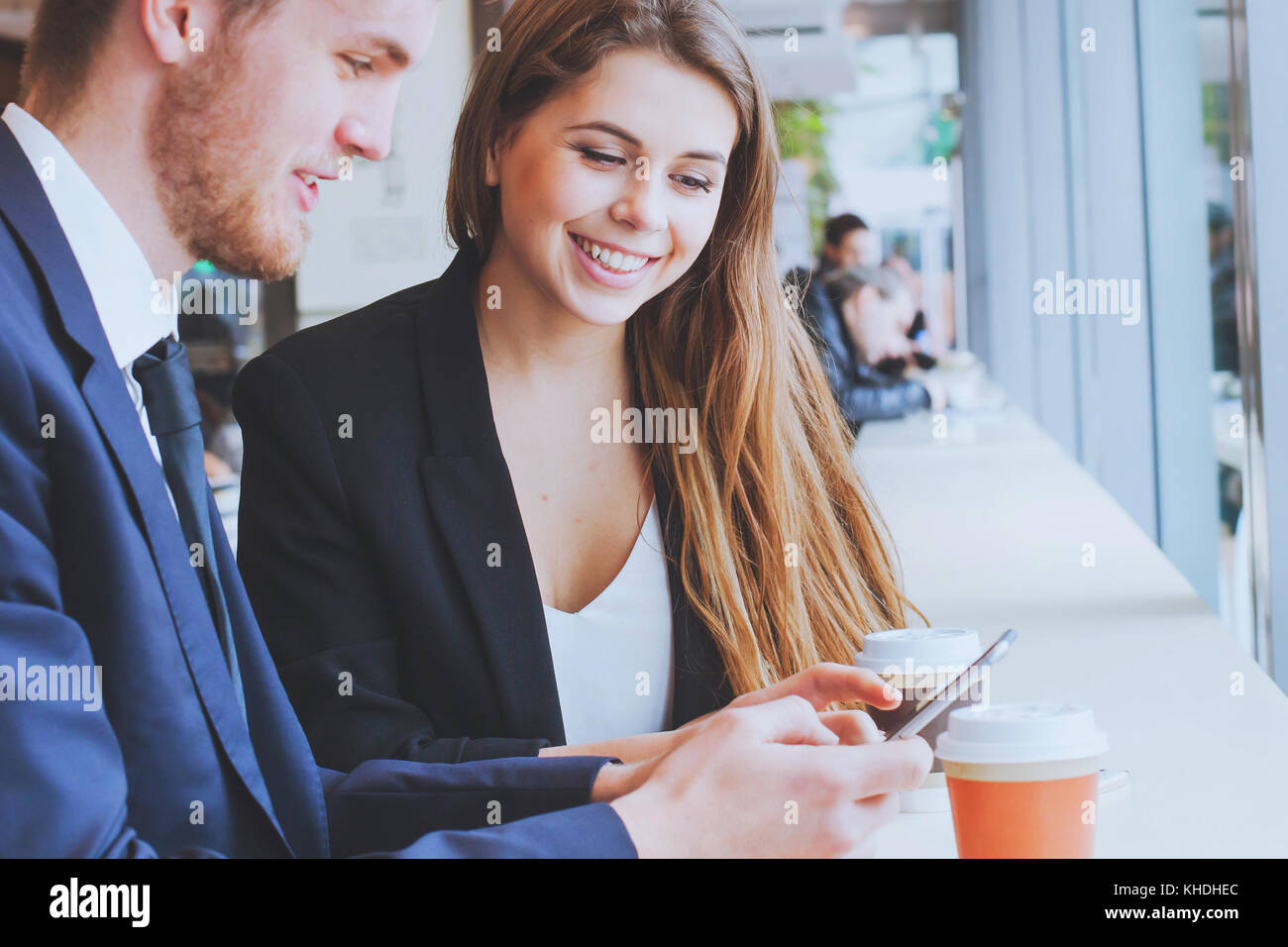 Sorridente la gente di affari utilizzando lo smartphone e di bere il caffè Foto Stock