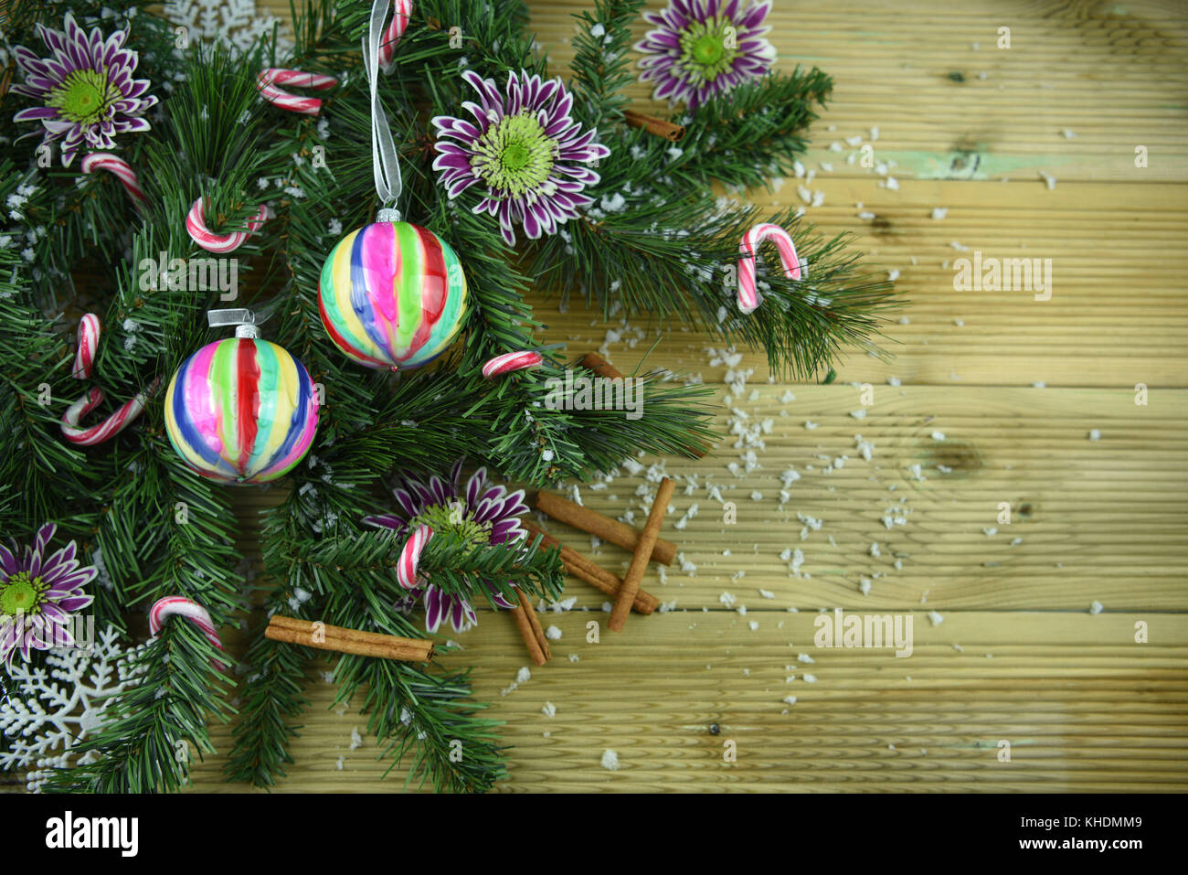 Gastronomia natalizia immagine di fotografia di verde albero di natale rami con bastoncini di cannella freschi fiori invernali baublesand candy canes spruzzata nella neve Foto Stock