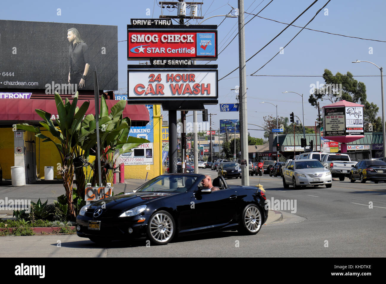 Autovettura convertibile e il traffico sulla Melrose Avenue vicino a Cole Ave e smog controllare 24 ora Car Wash segno di Hollywood, Los Angeles, California USA KATHY DEWITT Foto Stock