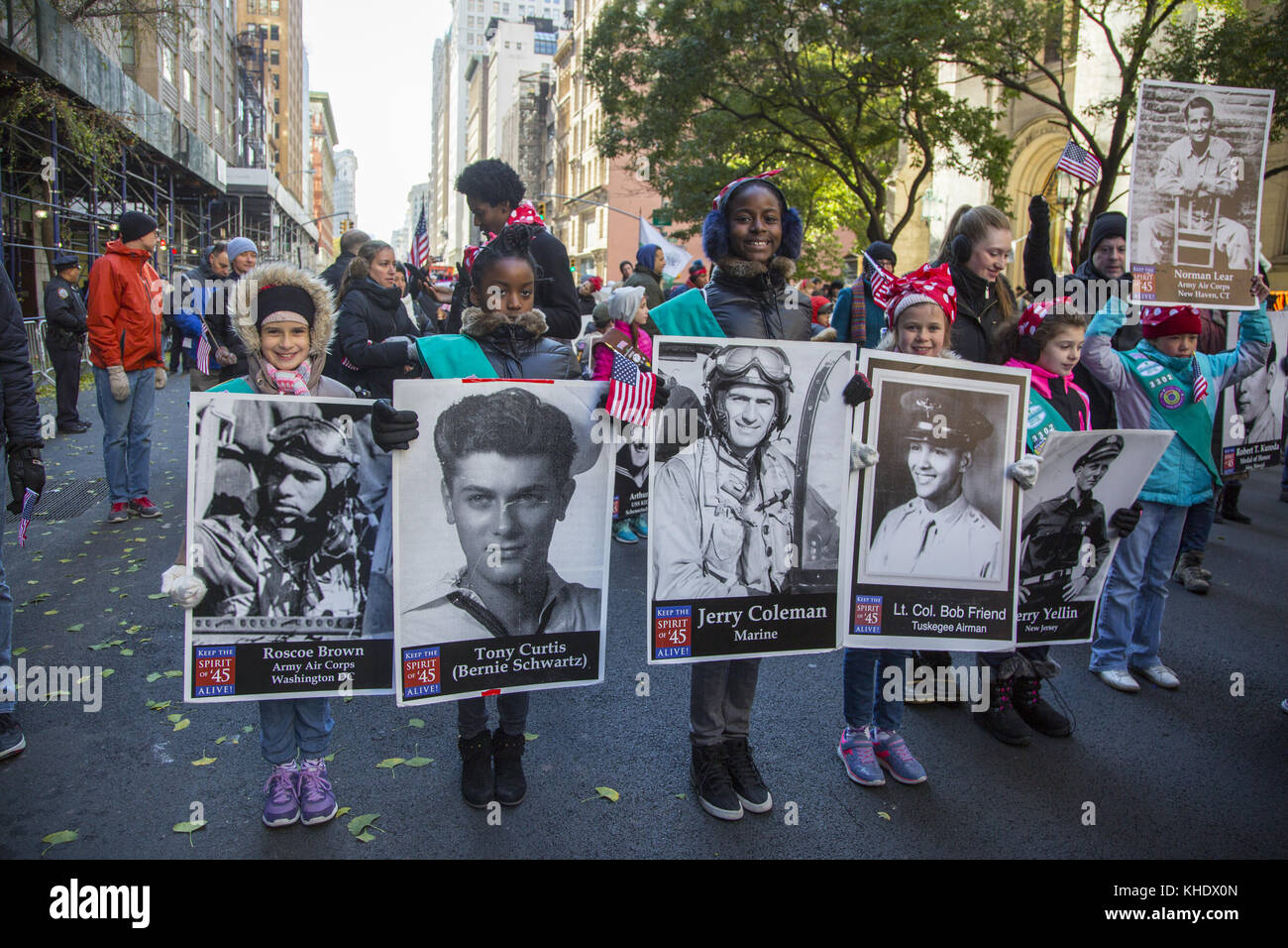 Girl Scouts onorano la marcia dei veterani della seconda Guerra Mondiale con le loro foto sulla 5a strada nella Veterans Day Parade a New York City. Foto Stock
