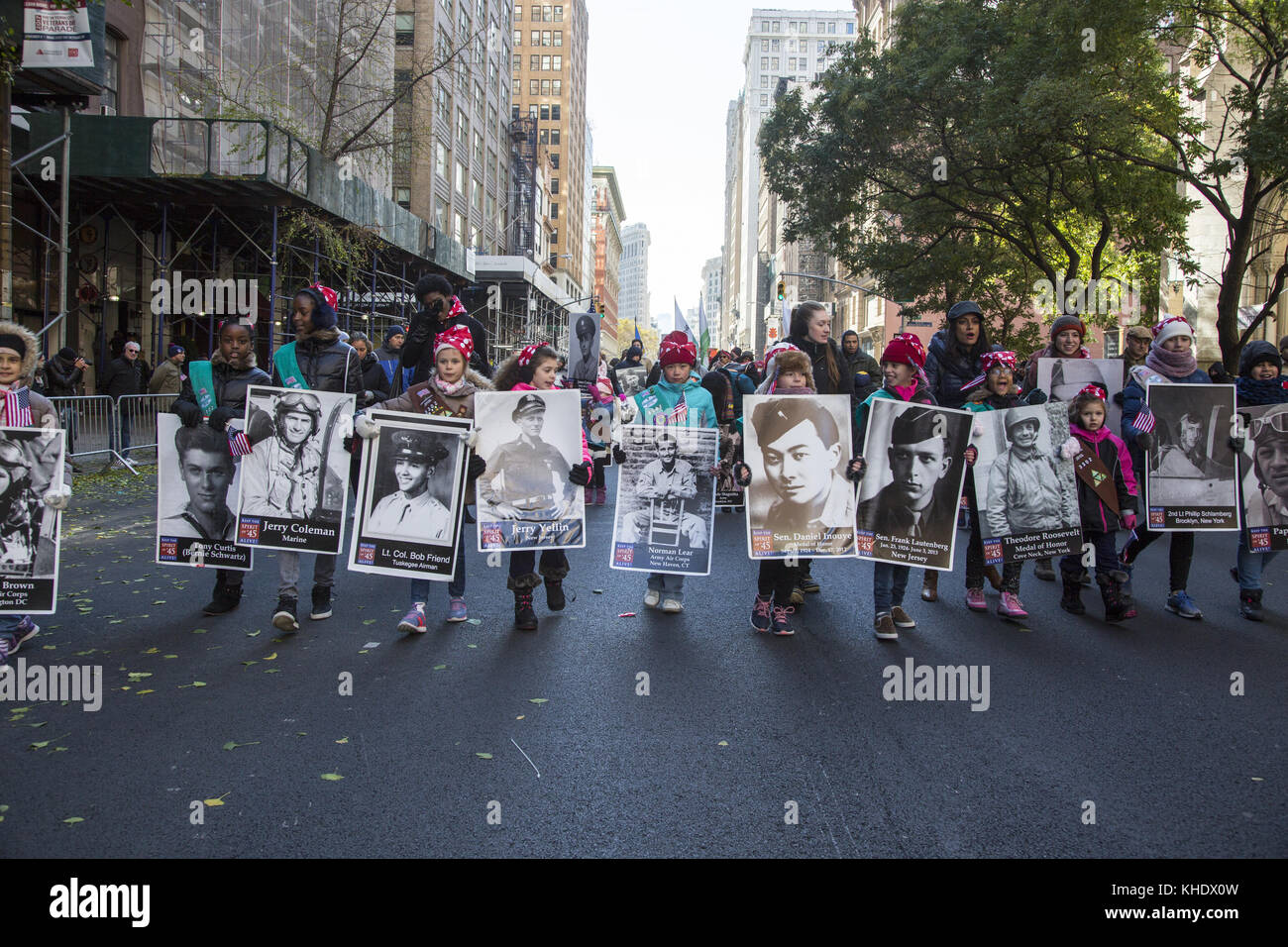 Girl Scouts onorano la marcia dei veterani della seconda Guerra Mondiale con le loro foto sulla 5a strada nella Veterans Day Parade a New York City. Foto Stock