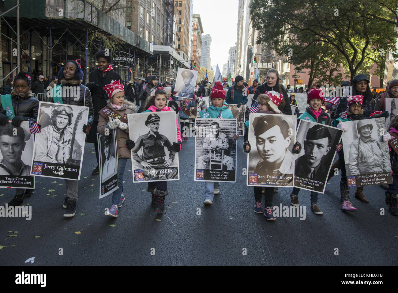 Girl Scouts onorano la marcia dei veterani della seconda Guerra Mondiale con le loro foto sulla 5a strada nella Veterans Day Parade a New York City. Foto Stock