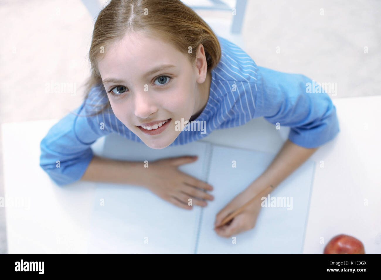 Bella ragazza con grandi occhi seduto e sorridente Foto Stock