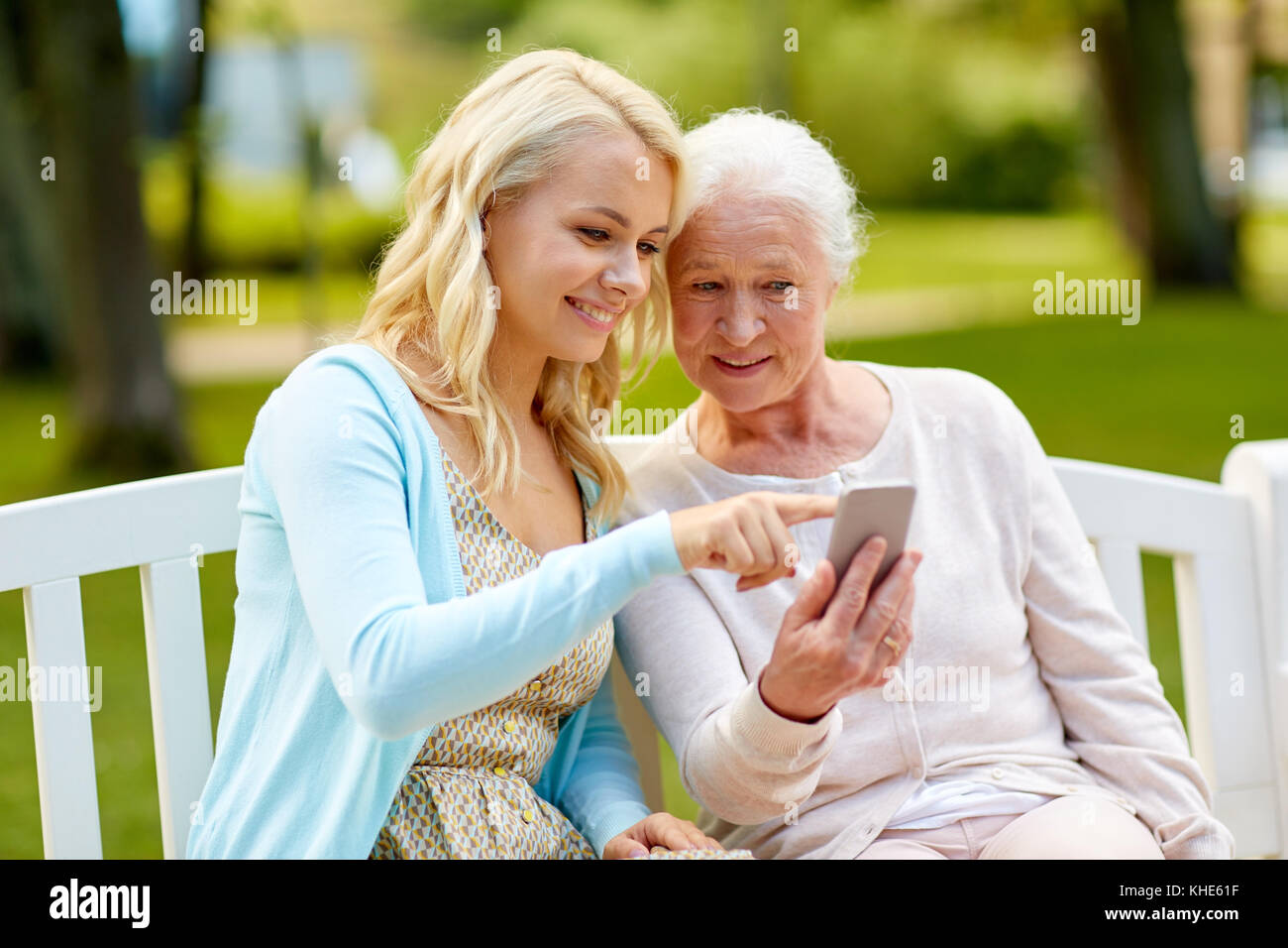 La figlia e la madre senior con lo smartphone in posizione di parcheggio Foto Stock