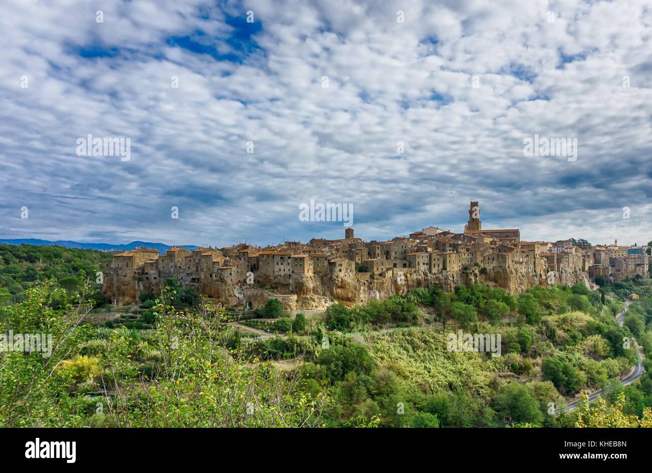 Foto orizzontale della città antica di Pitigliano in toscana italia. La città è costruita in pietra di tufo. strada che va alla città tra alberi e Foto Stock