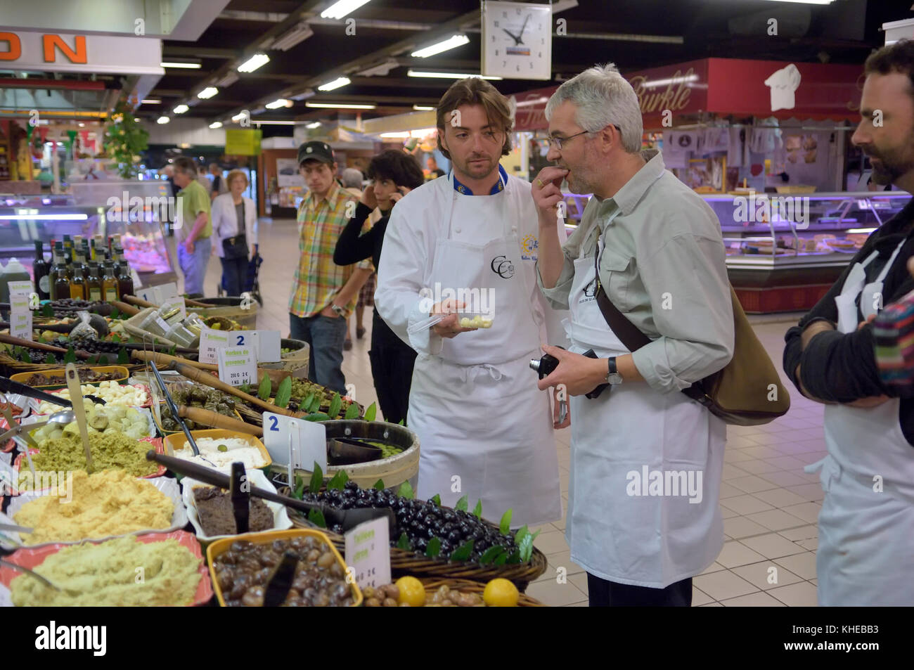 Una lezione di cucina che assaggia gli ingredienti al mercato interno Les Halles di Avignone, Provenza, Francia Foto Stock