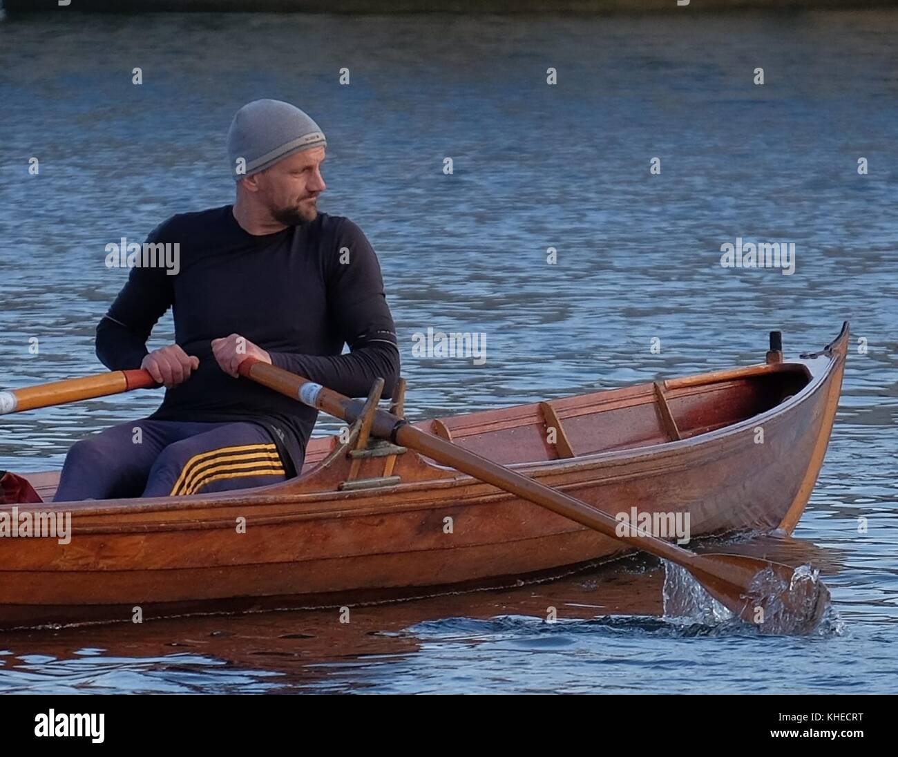 Uomo di canottaggio skiff di legno barca sul fiume Tamigi Foto Stock