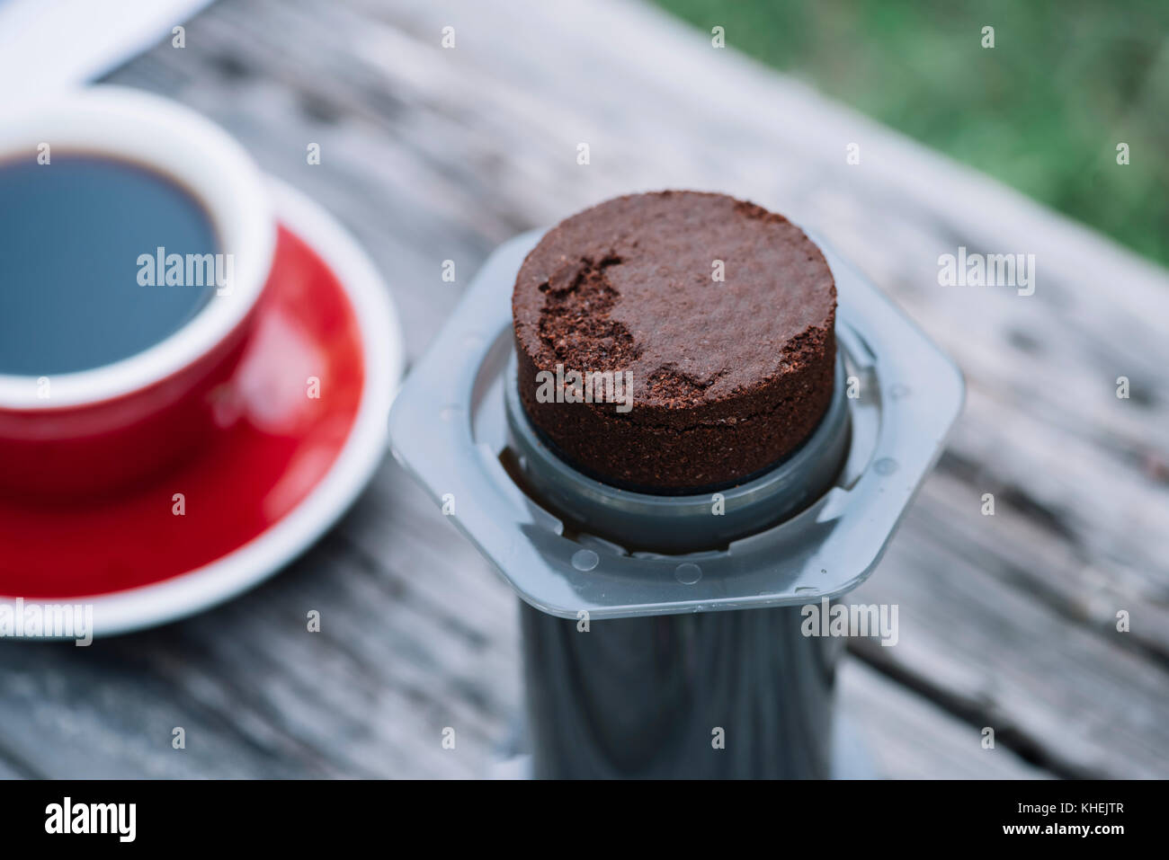 Il caffè fresco puck, sinistra da rendere filtro caffè all'aperto su un tavolo di legno sfondo Foto Stock