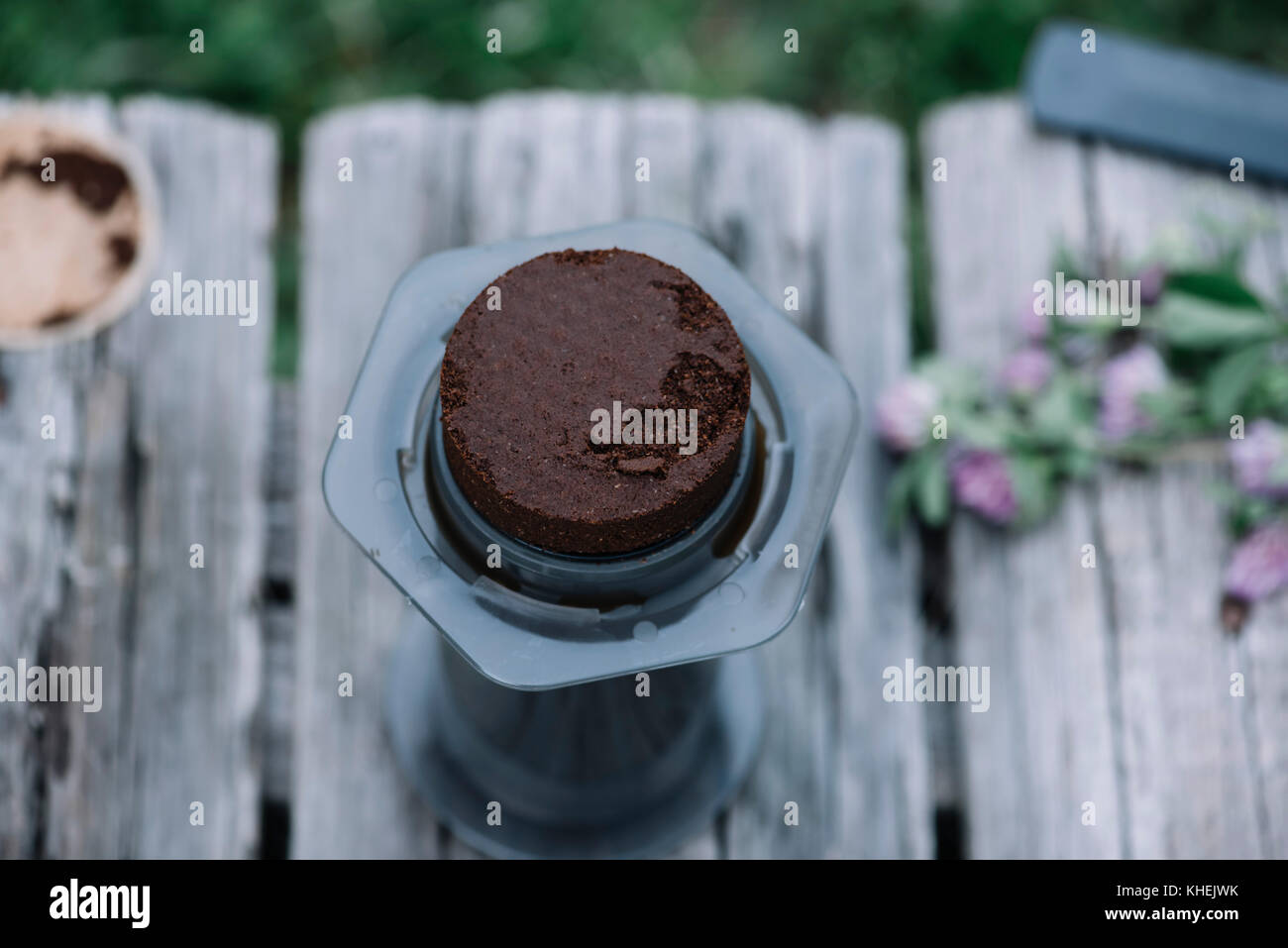 Il caffè fresco puck, sinistra da rendere filtro caffè all'aperto su un tavolo di legno sfondo Foto Stock