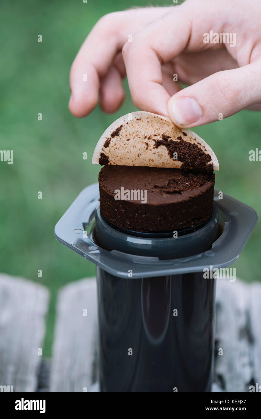 Il caffè fresco puck, sinistra da rendere filtro caffè all'aperto su un tavolo di legno sfondo Foto Stock