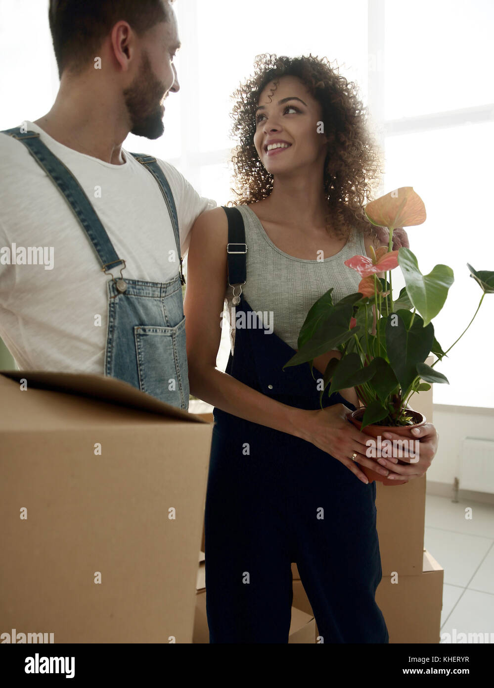 Gli sposi con scatole in piedi vicino a un nuovo appartamento. Foto Stock