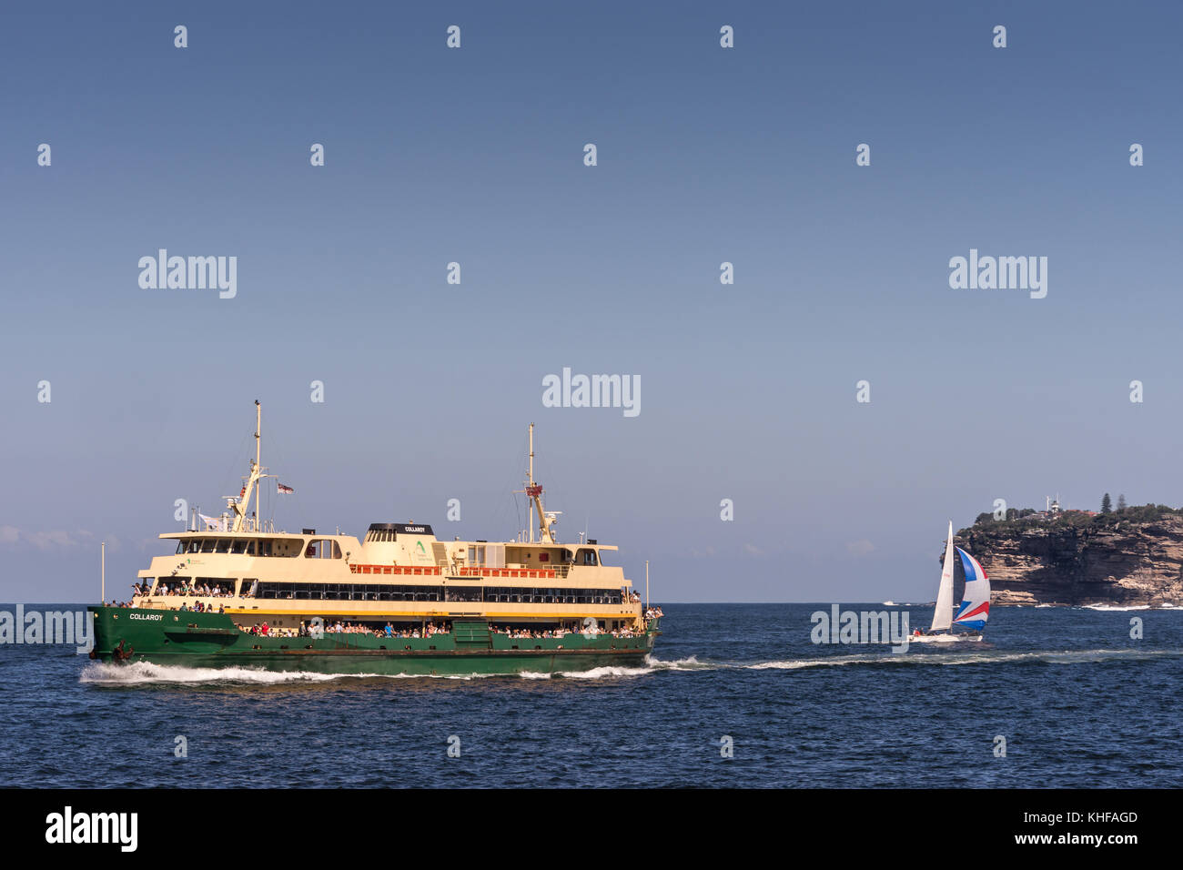 Sydney, Australia - 26 marzo 2017: collaroy verde-giallo ferry boat nella parte anteriore della presa a mare di tasman e south head scogliere. piccola barca a vela. tutte u Foto Stock