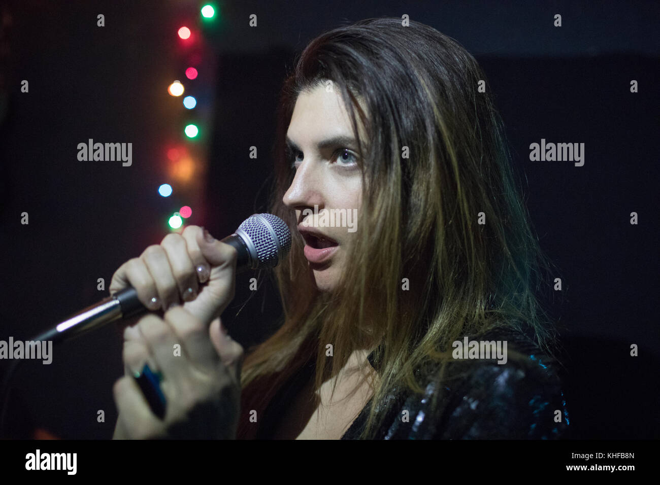 Giovane donna cantare a prove di banda Foto Stock