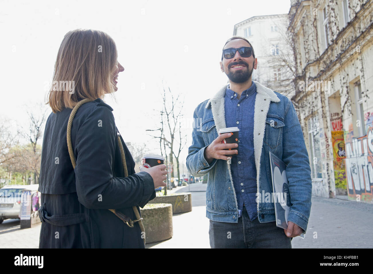 Coppia giovane di bere il caffè sul marciapiede Foto Stock