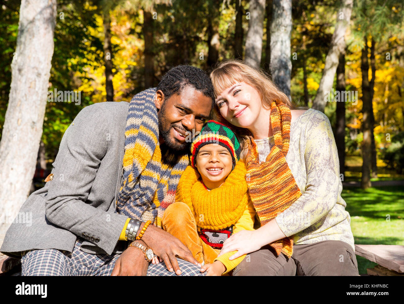Famiglia felice nel parco autunnale. Famiglia afroamericana: Padre nero, mamma e bambino bambino sulla natura in autunno. Foto Stock