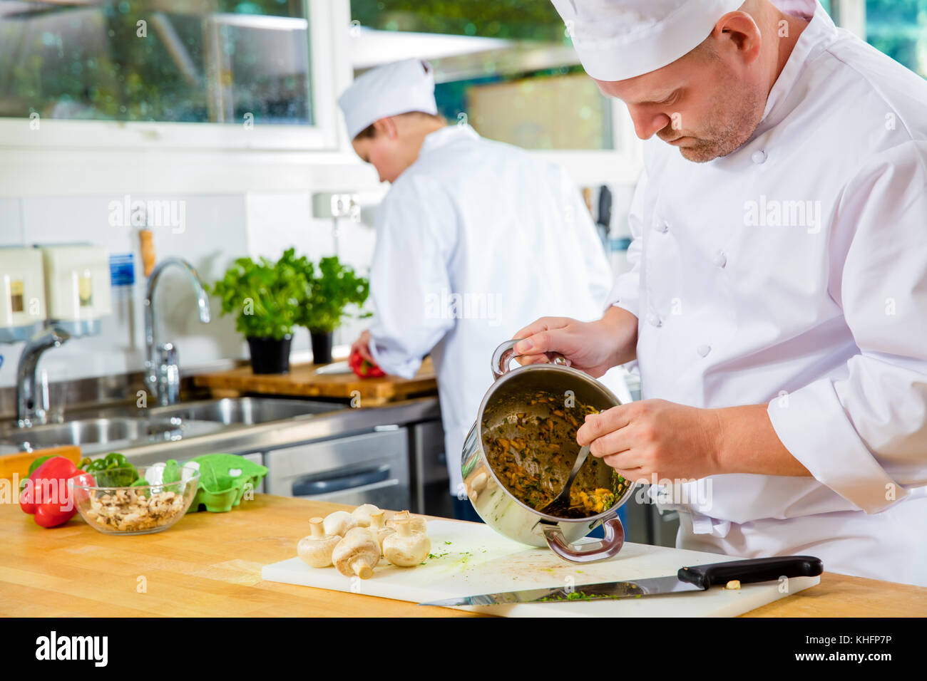Chef professionisti rende piatti nella cucina di grandi dimensioni Foto Stock