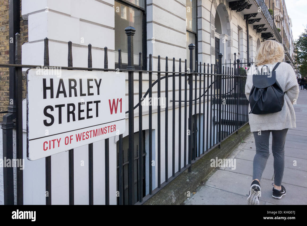 Una donna che cammina accanto alla famosa Harley Street, City of Westminster, W1, cartello stradale, Londra, Inghilterra, Regno Unito Foto Stock