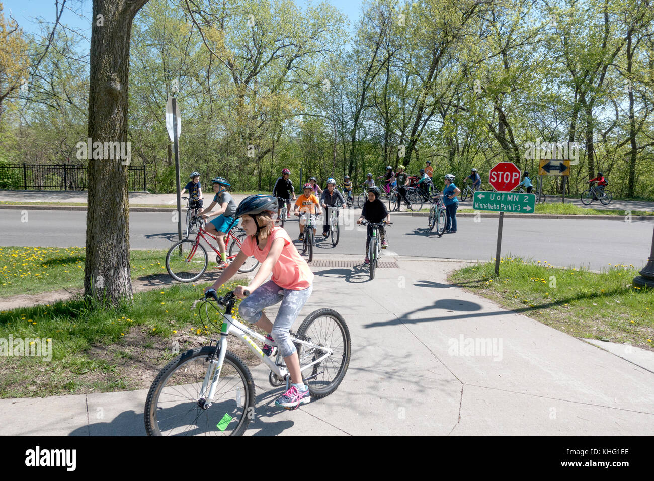 I bambini con età di 11 attraversando west river parkway su le loro biciclette indossare i caschi e immettendo il midtown greenway trail. Minneapolis Minnesota mn usa Foto Stock